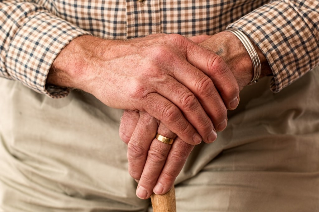 Old mans hands and walking stick