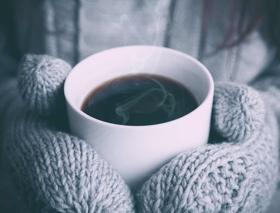 Gloves holding a cup of coffee whilst looking at high quality mobility scooters