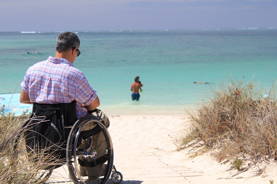 A man in a wheelchair on the beach.