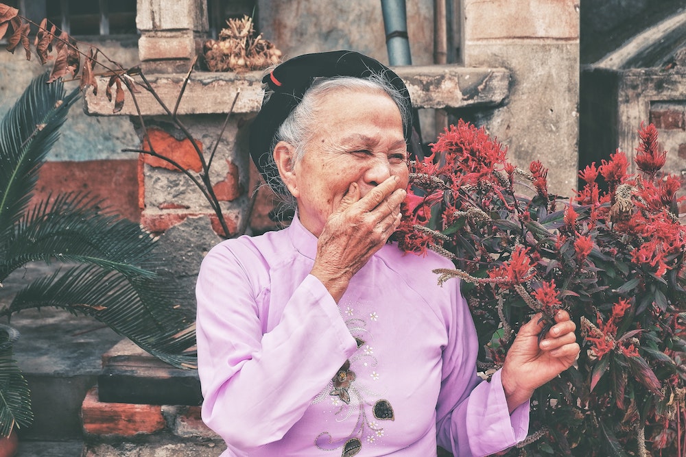 older lady laughing holding hand to her face