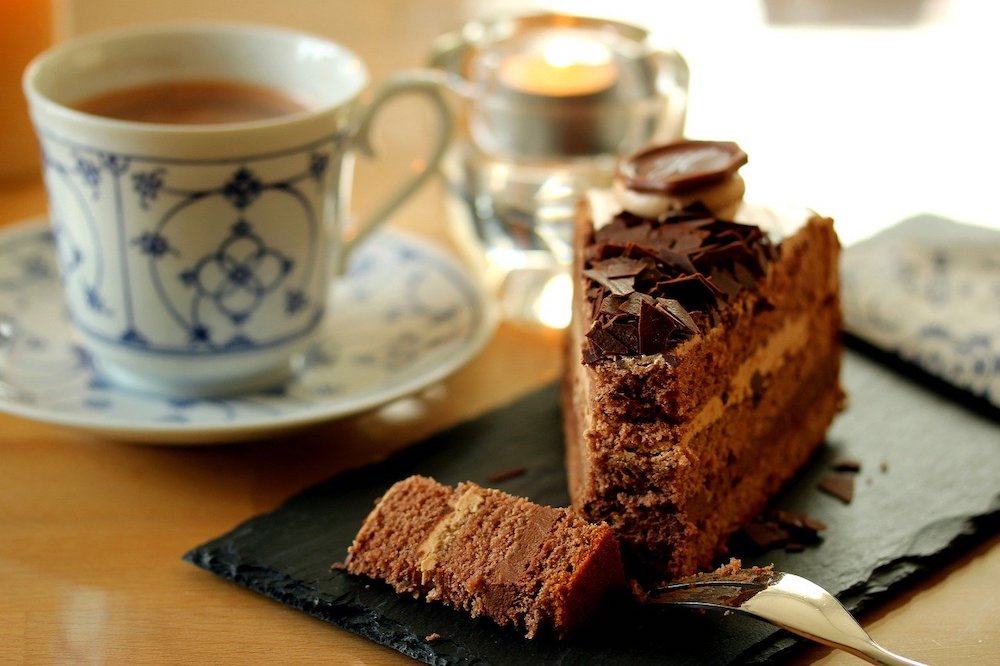 A cup of tea and slice of chocolate cake.