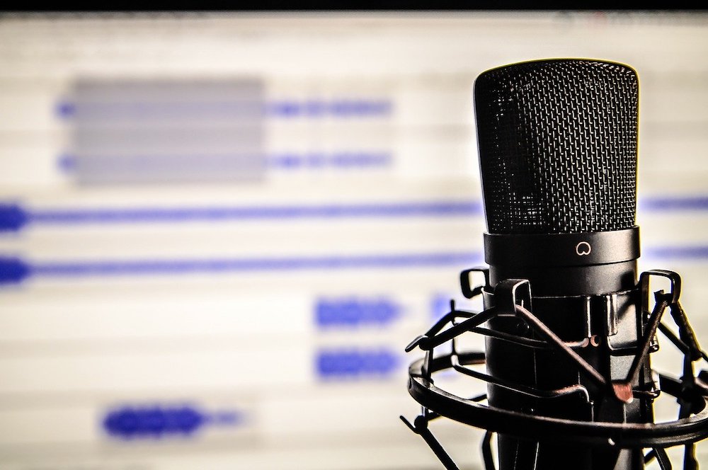 A microphone with a computer in the background.