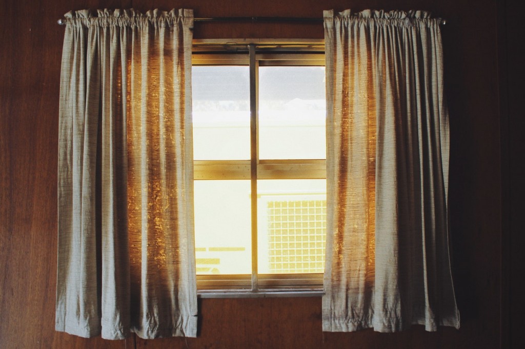 A window with cream curtains.